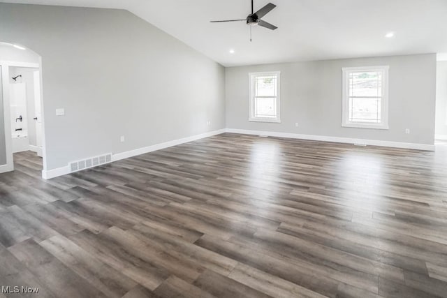 unfurnished room with lofted ceiling, dark hardwood / wood-style floors, ceiling fan, and a wealth of natural light