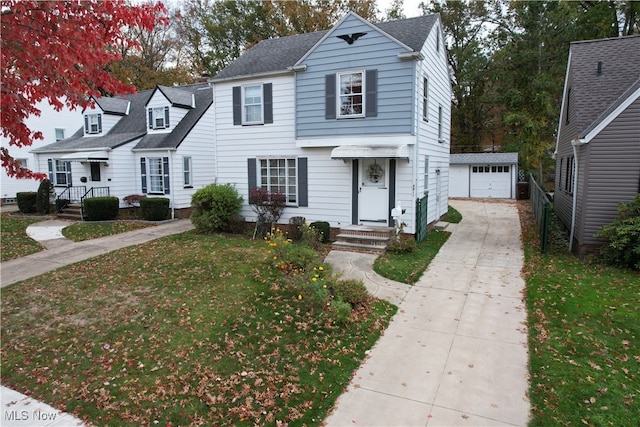 view of front of home with a front yard, a garage, and an outdoor structure