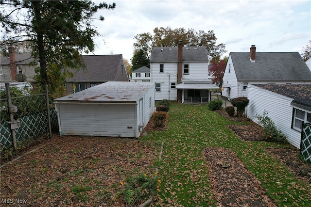 rear view of house featuring a shed and a lawn