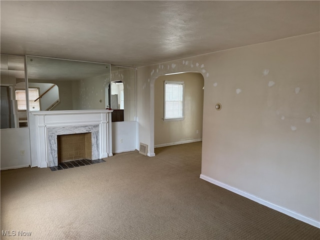 unfurnished living room featuring a premium fireplace and carpet floors