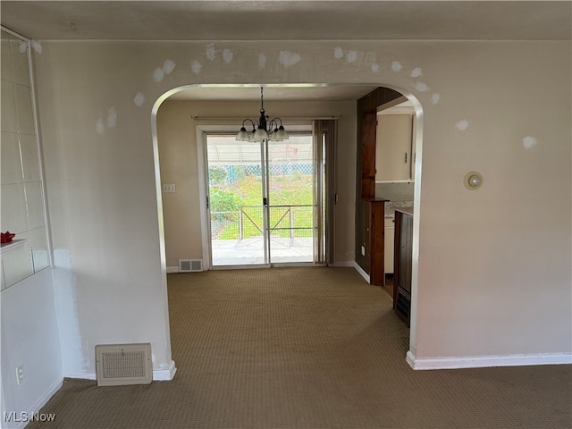 unfurnished dining area with a notable chandelier and carpet flooring