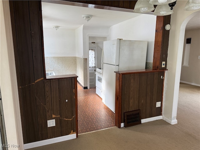 kitchen featuring carpet floors and white appliances