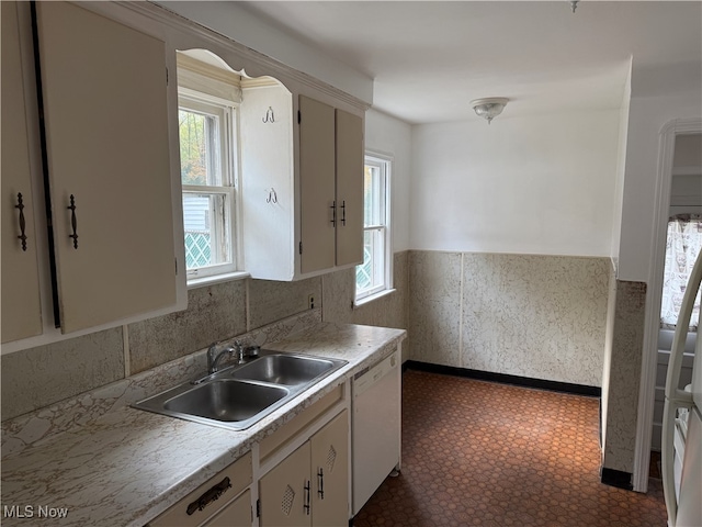 kitchen with white cabinetry, a healthy amount of sunlight, sink, and white dishwasher