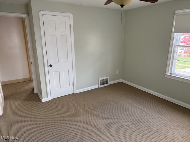 empty room with carpet floors and ceiling fan