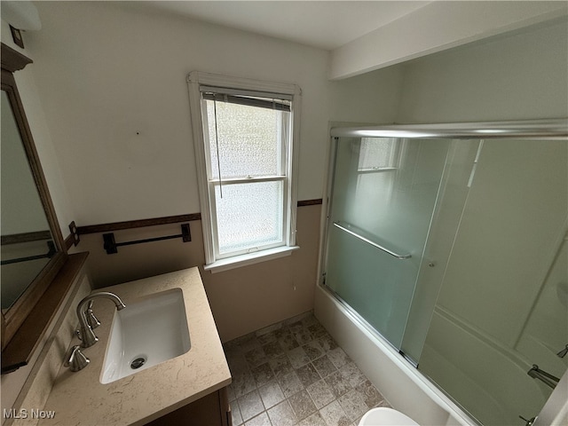 full bathroom with vanity, enclosed tub / shower combo, and toilet