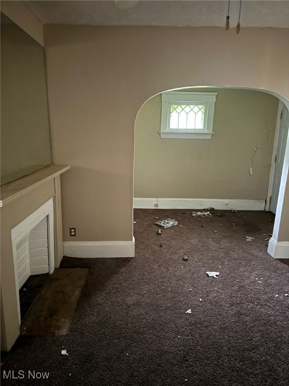 unfurnished living room featuring dark colored carpet