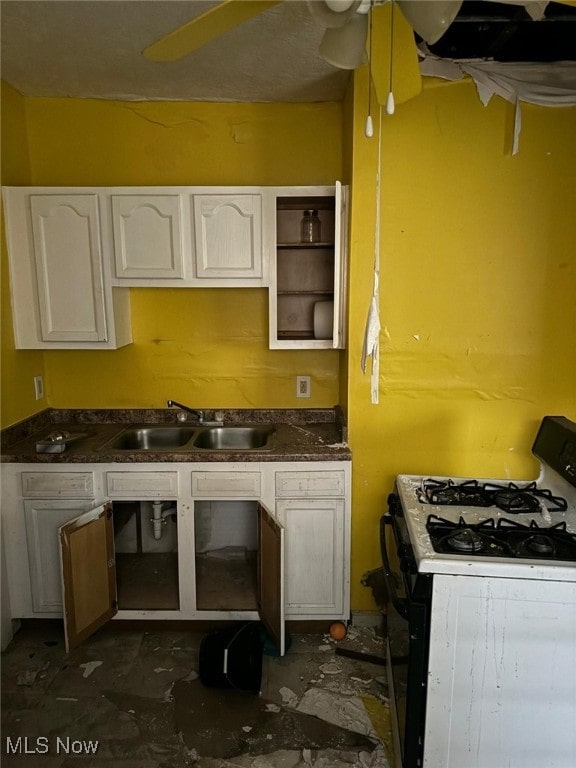 kitchen with sink, white cabinets, white gas range, and ceiling fan