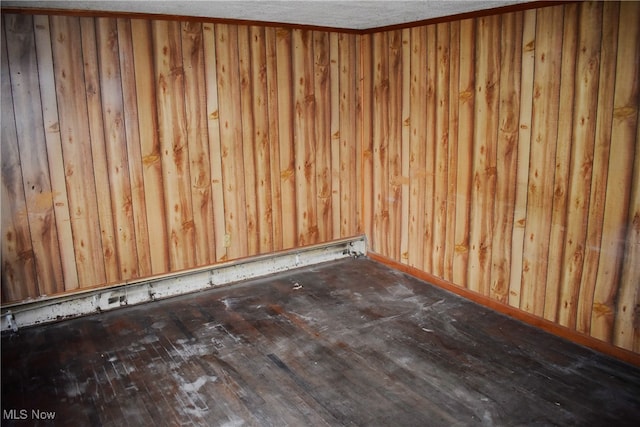 empty room featuring hardwood / wood-style flooring and wooden walls