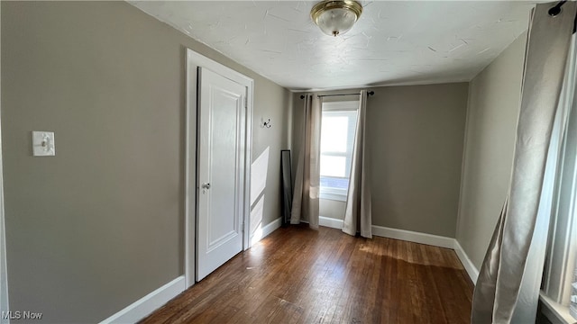 unfurnished room featuring dark wood-type flooring