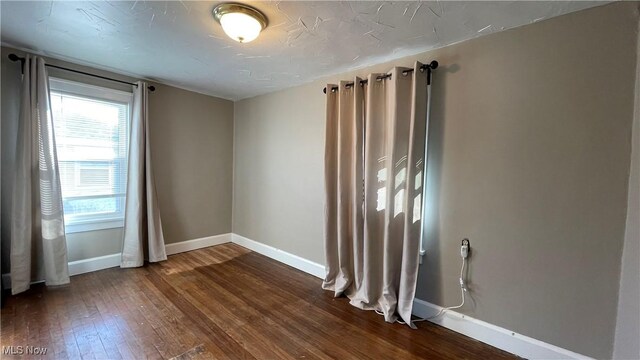 empty room featuring dark wood-type flooring