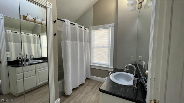 bathroom with vanity, shower / tub combo, hardwood / wood-style flooring, and lofted ceiling