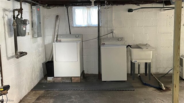 laundry area featuring electric panel, sink, and washer and clothes dryer