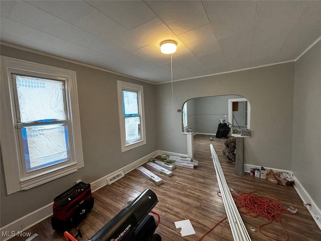 exercise area with wood-type flooring and crown molding