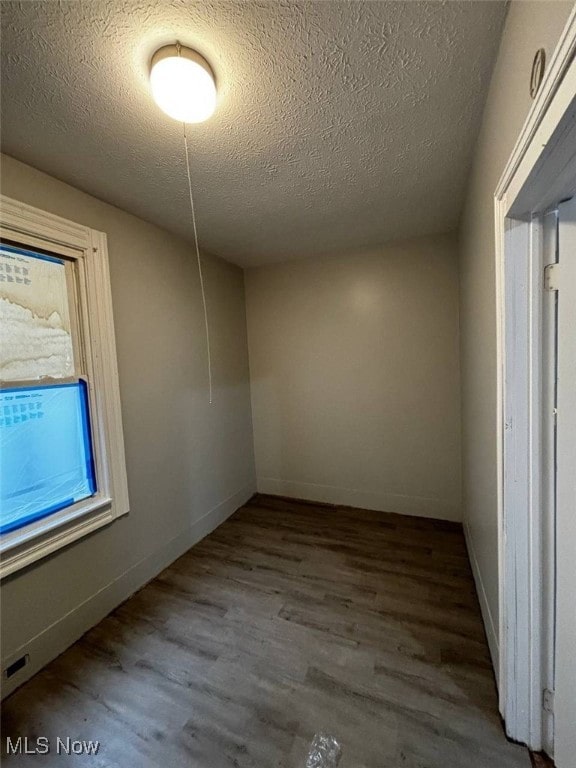 spare room featuring hardwood / wood-style floors and a textured ceiling