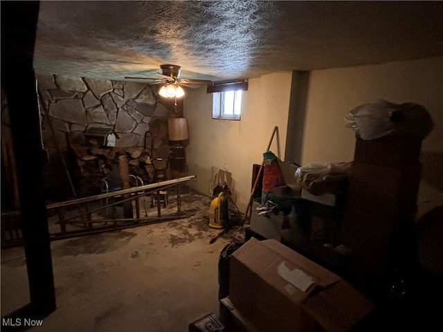 basement featuring ceiling fan and a textured ceiling