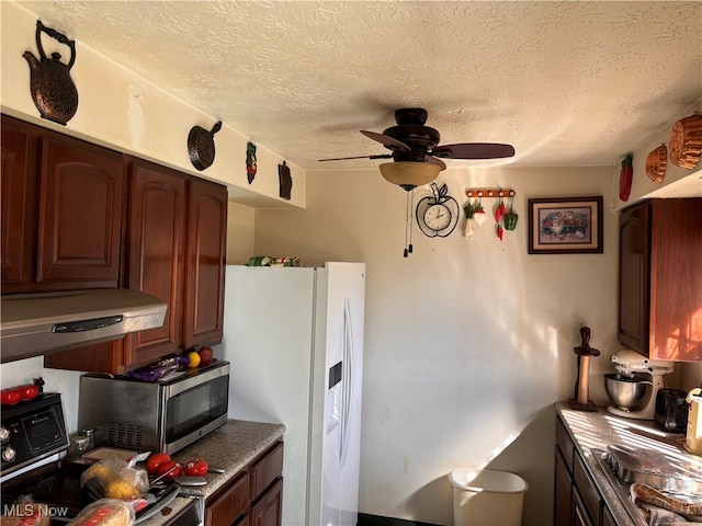 kitchen with ceiling fan, a textured ceiling, appliances with stainless steel finishes, and ventilation hood