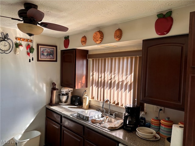 kitchen with a textured ceiling, sink, dark brown cabinets, and ceiling fan