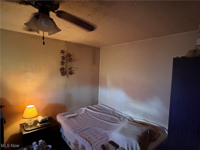 bedroom with a textured ceiling and ceiling fan