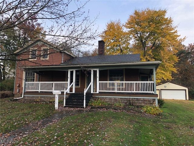 view of front property with a front yard, an outdoor structure, a garage, and a porch