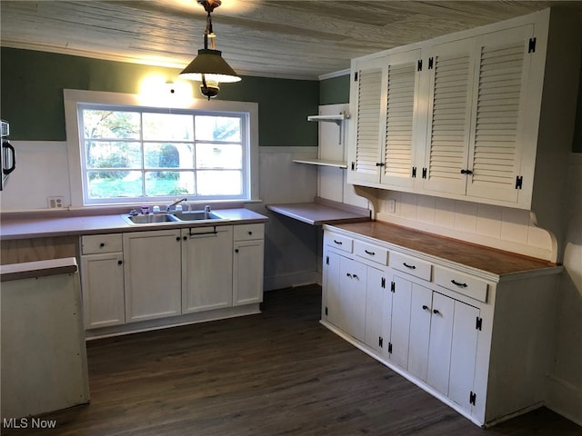 kitchen featuring sink, white cabinetry, pendant lighting, and dark hardwood / wood-style floors