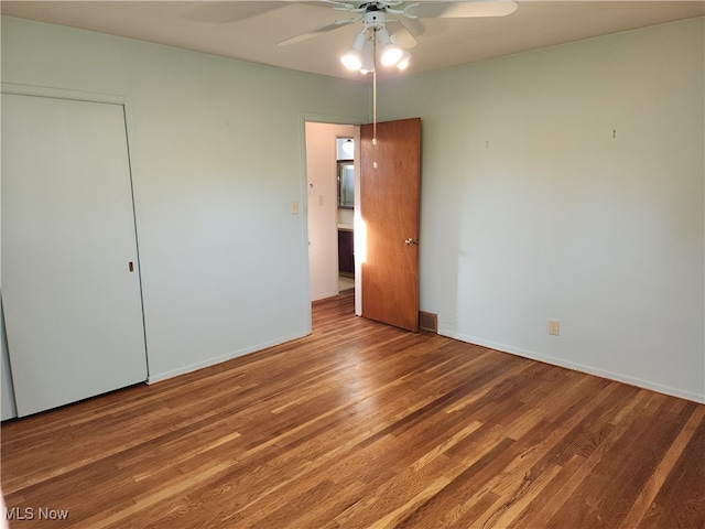 unfurnished bedroom with a closet, hardwood / wood-style floors, and ceiling fan