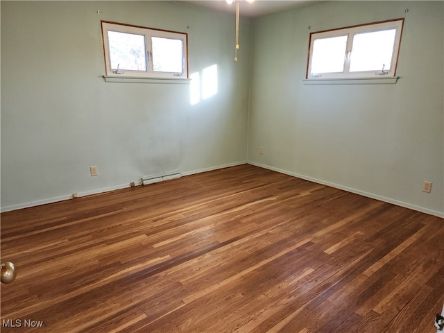 spare room featuring a baseboard radiator, ceiling fan, hardwood / wood-style flooring, and a wealth of natural light