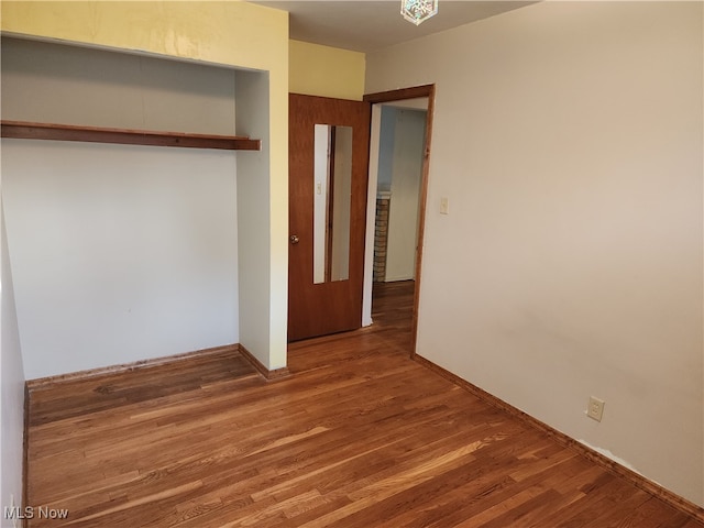 unfurnished bedroom with a closet and hardwood / wood-style floors