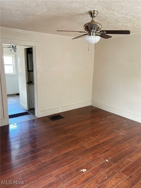 empty room featuring a textured ceiling and dark hardwood / wood-style floors