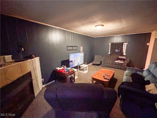 living room with ornamental molding, a fireplace, and wooden walls