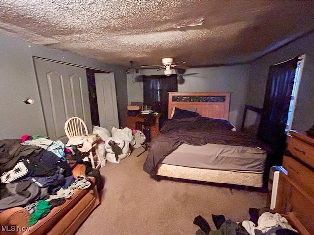 bedroom with a textured ceiling, a closet, ceiling fan, and carpet floors