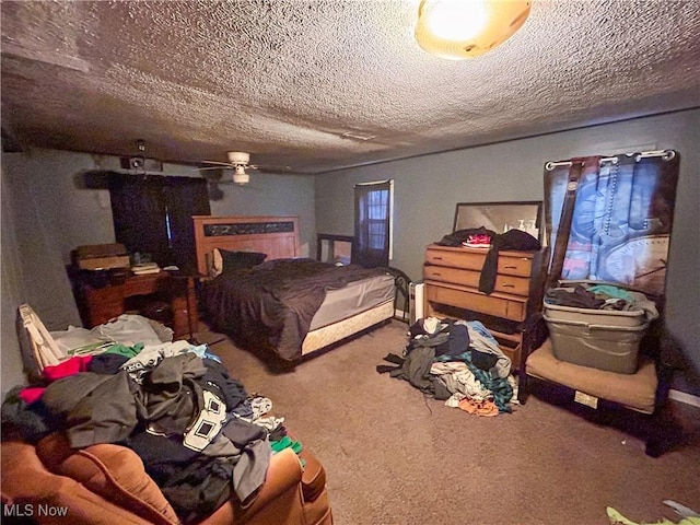 bedroom with ceiling fan, carpet floors, and a textured ceiling