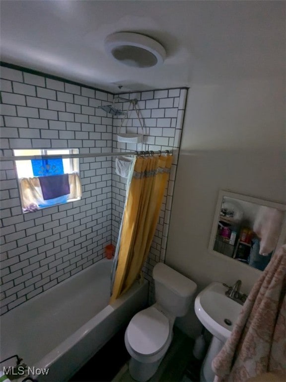 full bathroom featuring sink, shower / bath combination with curtain, and toilet