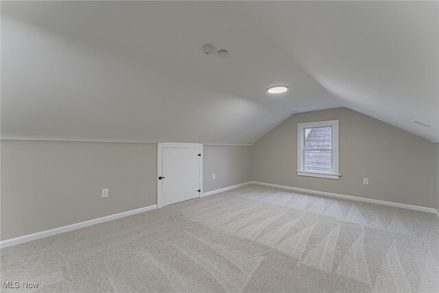 bonus room with light carpet and lofted ceiling