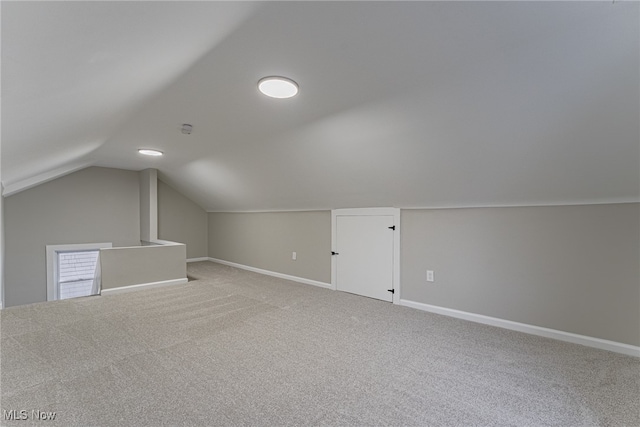 bonus room with light carpet and vaulted ceiling