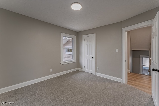 unfurnished bedroom with a closet, a textured ceiling, and light colored carpet