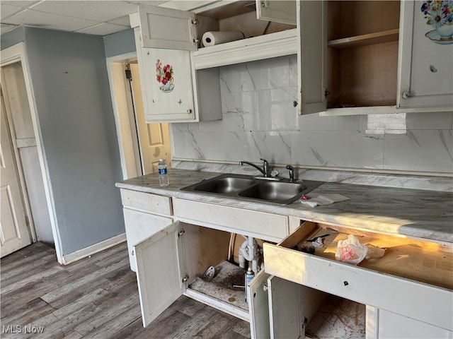 kitchen featuring a paneled ceiling, sink, wood-type flooring, and backsplash