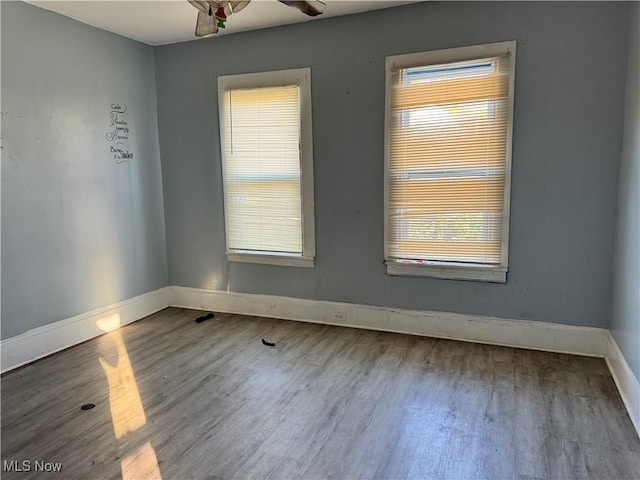 spare room featuring baseboards and wood finished floors