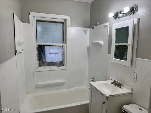 full bathroom featuring toilet, shower / tub combination, vanity, and tile walls