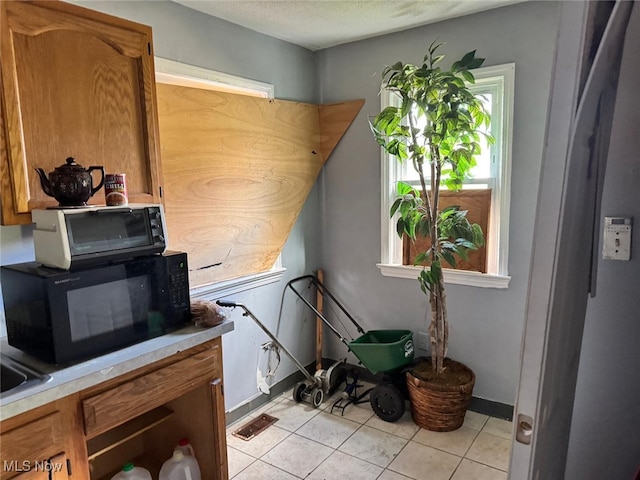 miscellaneous room featuring light tile patterned floors and a textured ceiling