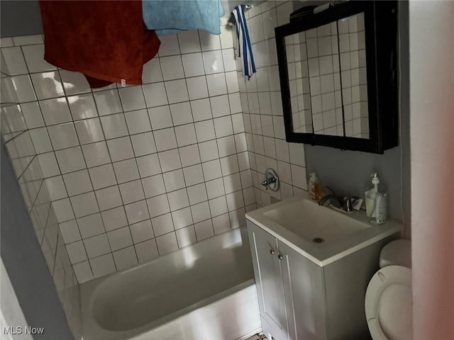 full bathroom featuring tiled shower / bath combo, vanity, and toilet