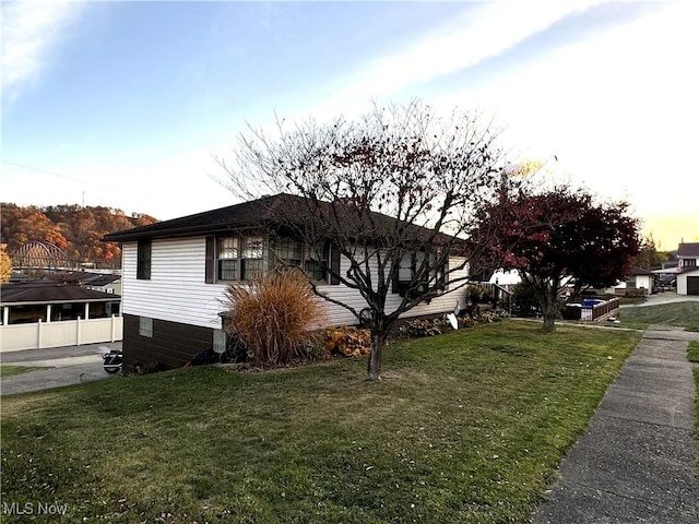 property exterior at dusk with a lawn