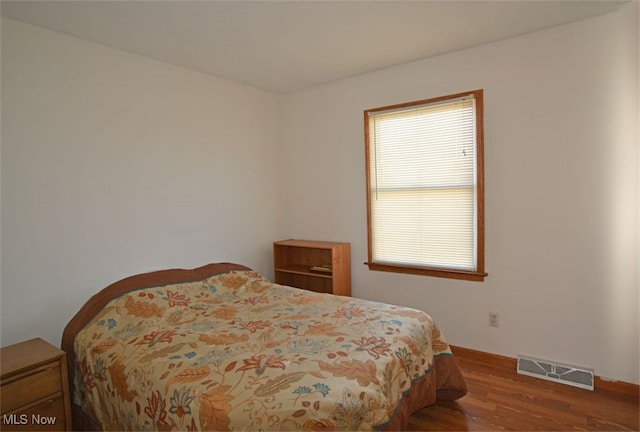 bedroom with multiple windows and wood-type flooring