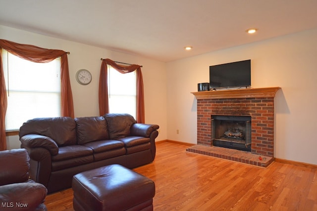 living room with hardwood / wood-style floors and a brick fireplace