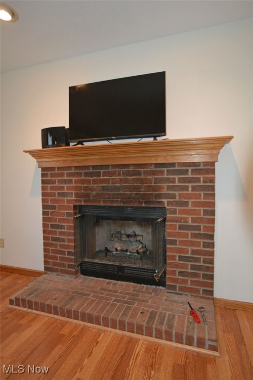 room details with hardwood / wood-style flooring and a brick fireplace