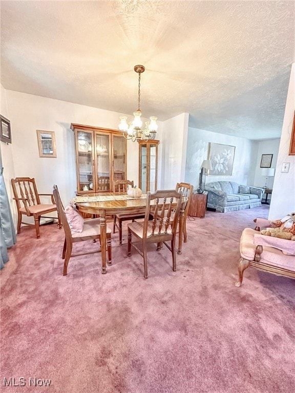 carpeted dining room featuring a textured ceiling and a chandelier