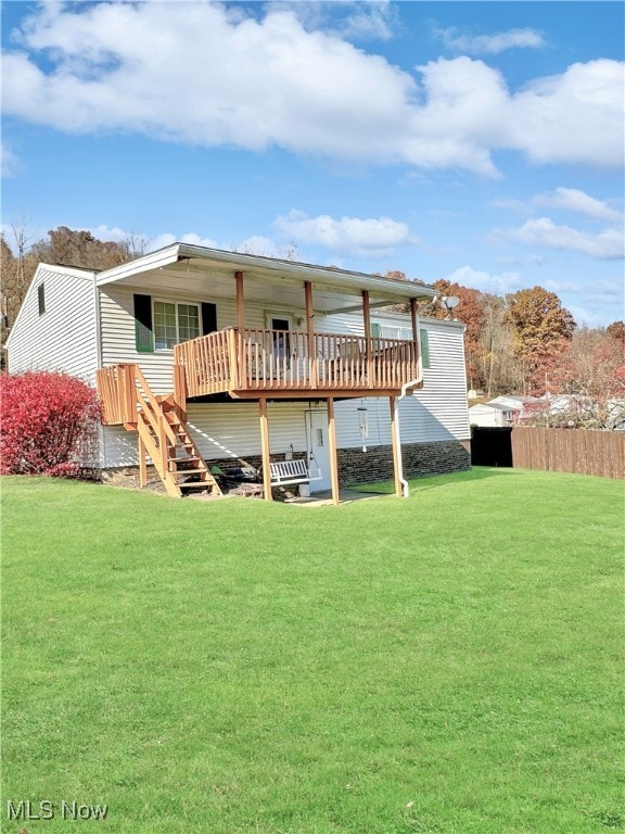 back of property with a wooden deck and a lawn