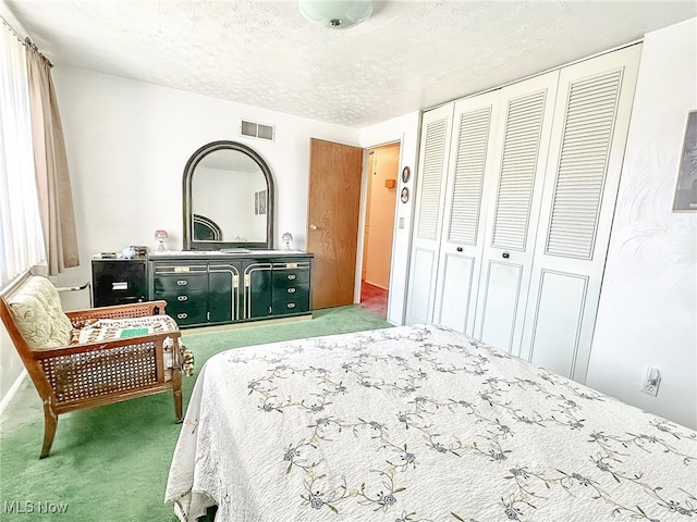 bedroom with a textured ceiling, carpet floors, and a closet