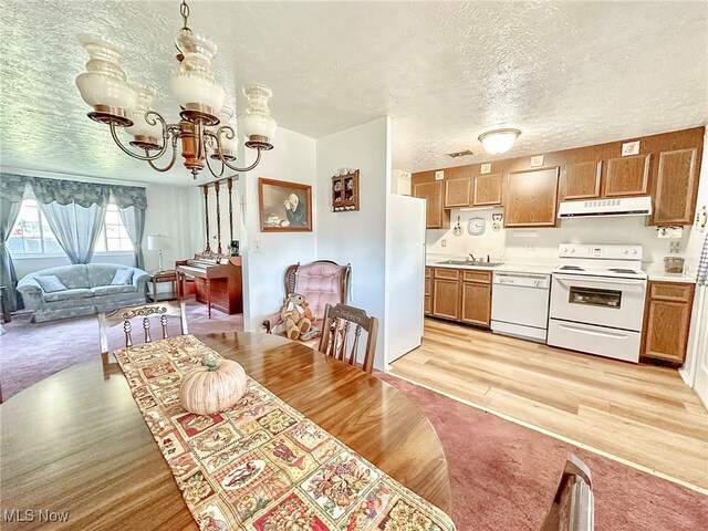 dining area with light hardwood / wood-style floors, a textured ceiling, and sink