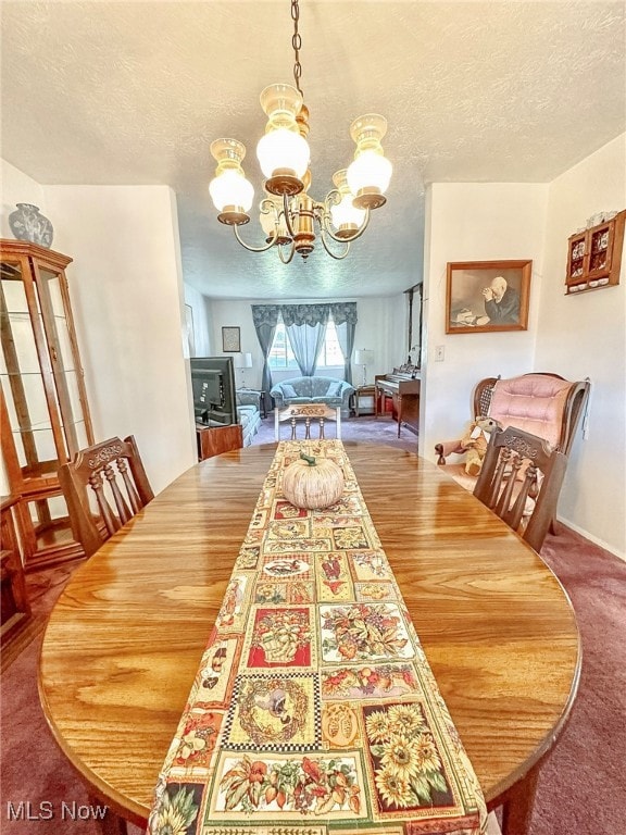 dining space with a textured ceiling and an inviting chandelier