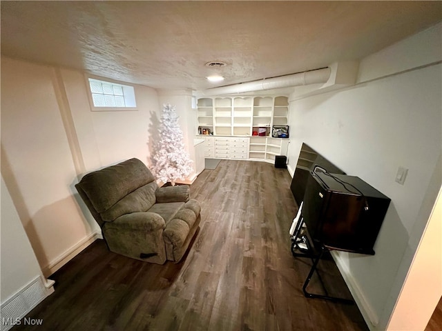 living area with a textured ceiling and dark hardwood / wood-style flooring